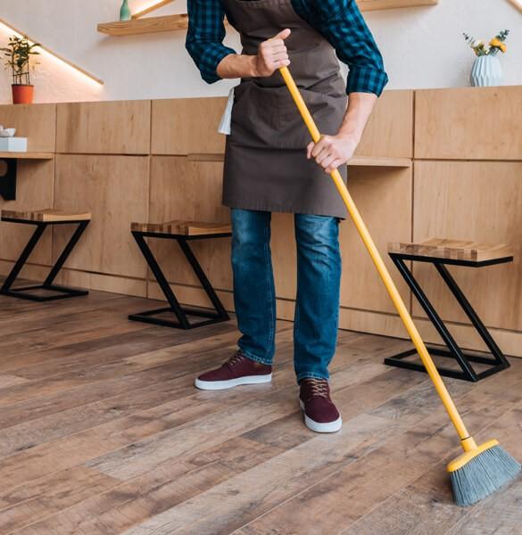 Man sweeping hardwood floors | Flooring Direct