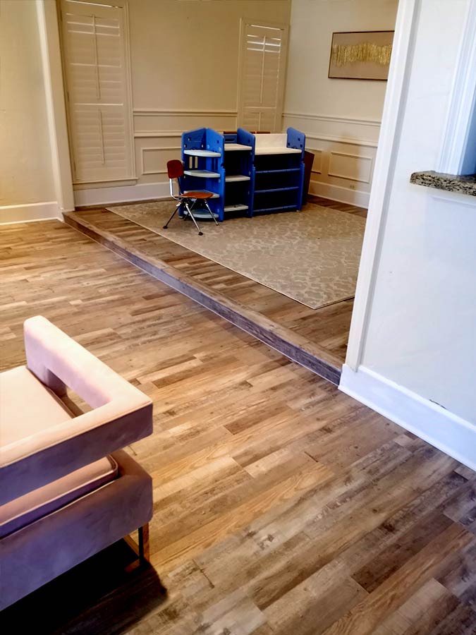 Transitions like this step up shown here are the reasons why it is important to have a flooring expert from Flooring Direct do a Free Estimate appointment so they are included in your project.
