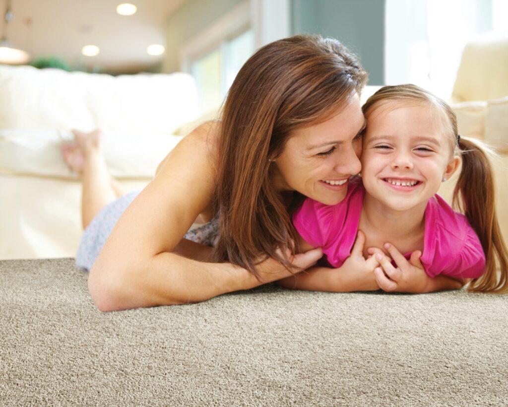Mom playing with baby laying on carpet floor | Flooring Direct