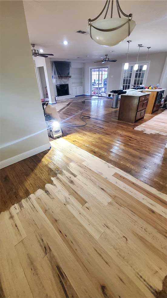 Flooring Direct sands this installed hickory hardwood flooring to perform custom hand-scraping and high-gloss finish.
