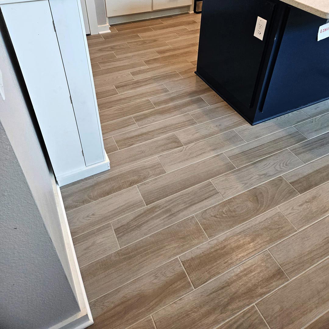 Wood-look Porcelain Tile and Installation performed by Flooring Direct in Grand Prairie featuring a kitchen scene.