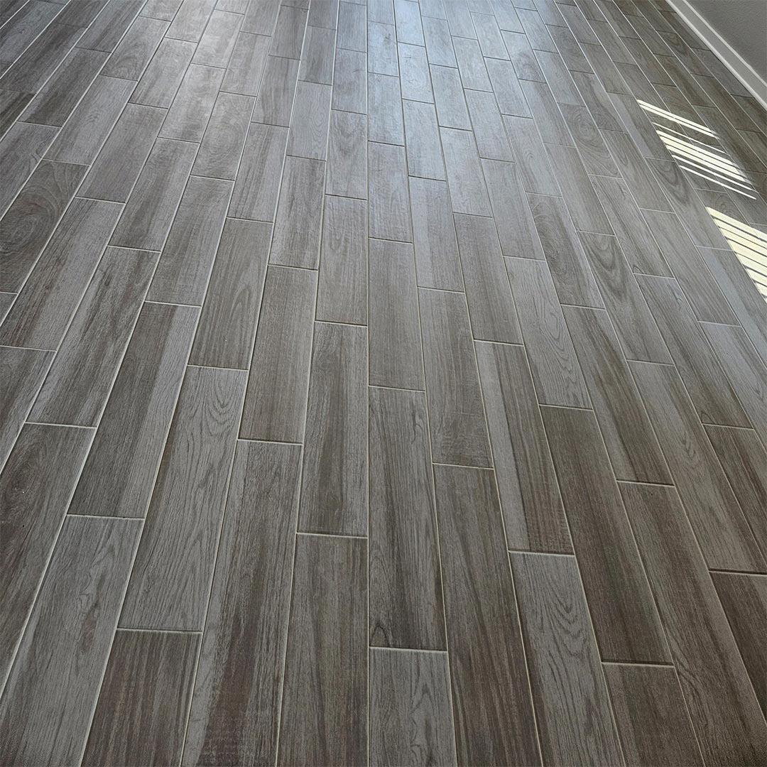 Wood-look Porcelain Tile and Installation performed by Flooring Direct in Grand Prairie featuring a living room scene.