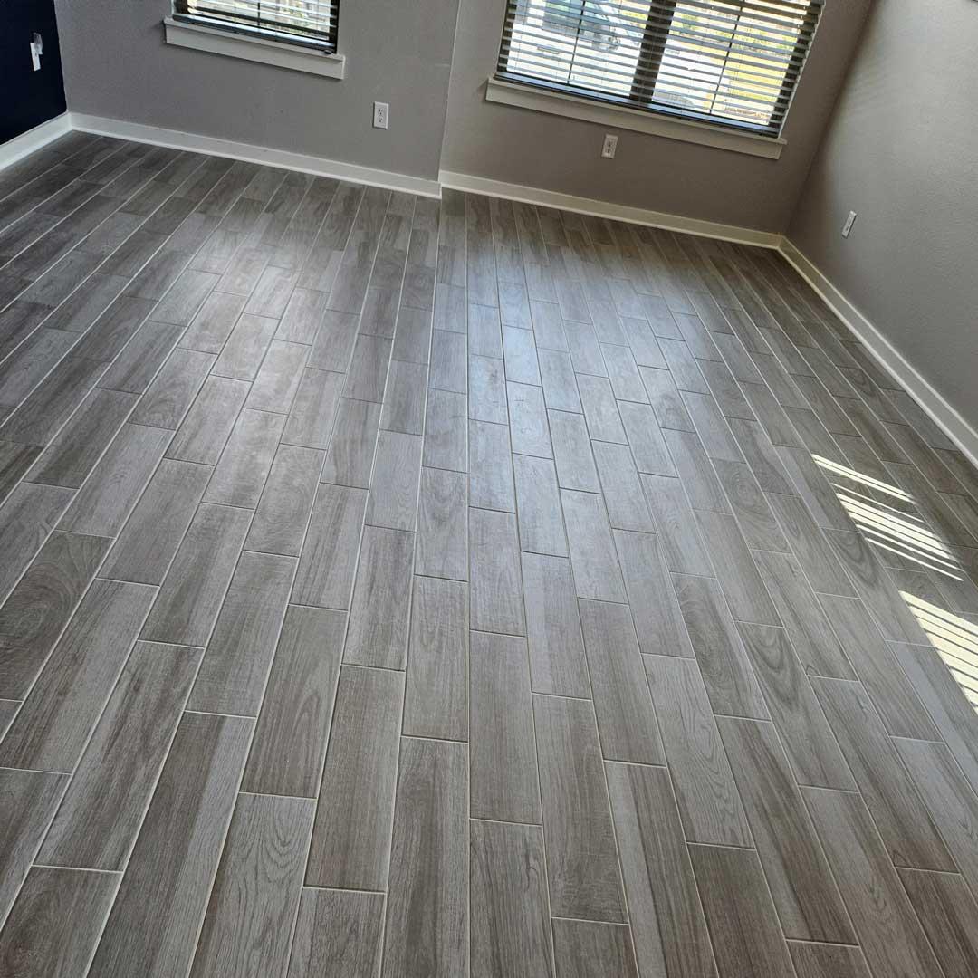Wood-look Porcelain Tile and Installation performed by Flooring Direct in Grand Prairie featuring a living room scene.